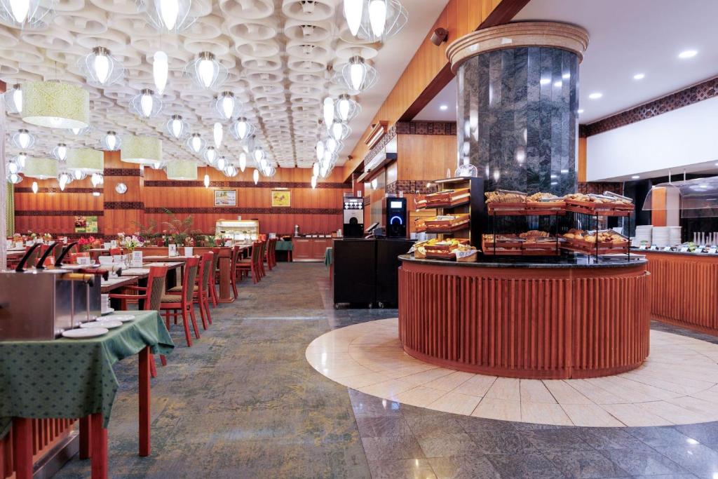 a restaurant with tables and a counter with pastries at Ensana Thermal Hévíz in Hévíz