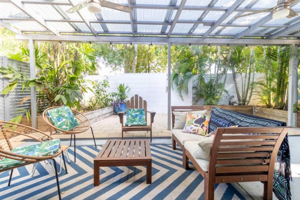 a screened porch with chairs and a couch at Tropical Garden Villa 5 mins from City Centre in Paraparap