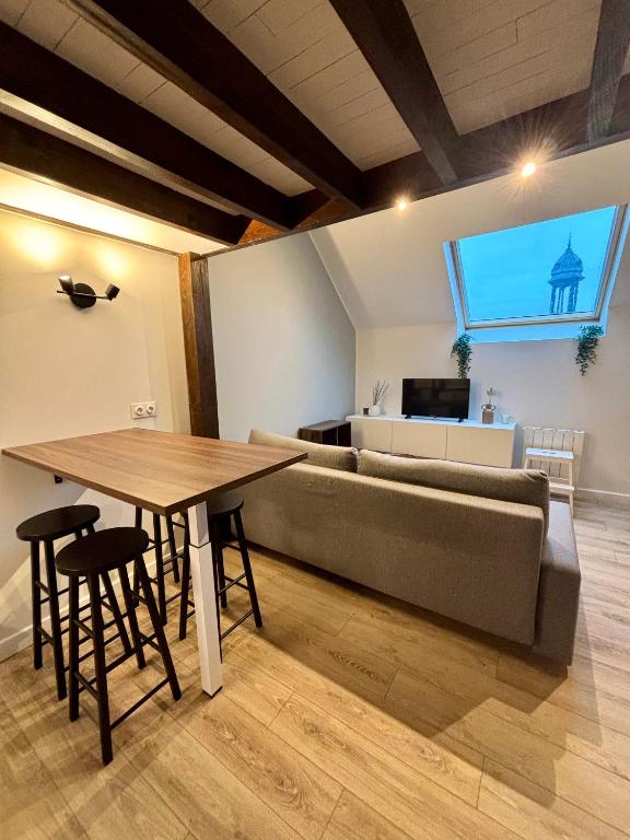 a living room with a couch and a table at Le Petit Jardin, proche gare, hyper centre in Cambrai