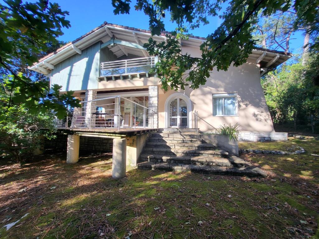 a house with a large balcony on the front of it at Villa PERICA pour 10 personnes. Entre lac et océan. Wifi gratuit. in Soorts-Hossegor