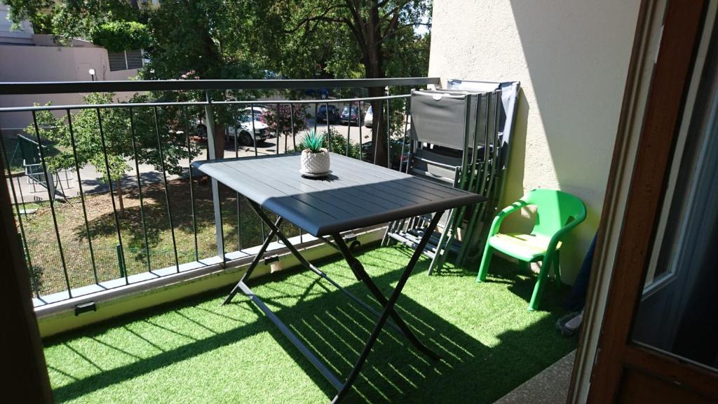 - une table sur un balcon avec une plante en pot dans l'établissement Cannes proche croisette, à Cannes