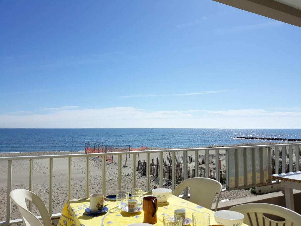 une table sur un balcon avec vue sur la plage dans l'établissement T2 CABINE-Superbe vue mer et accès direct plage proche commerces-6AT28, à Saint Cyprien Plage
