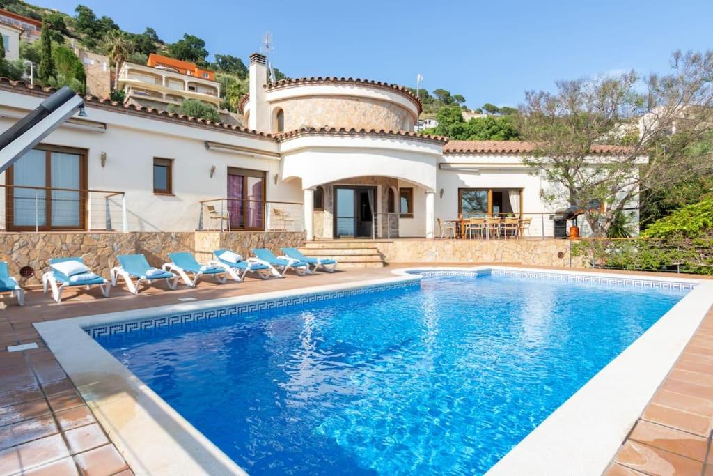 a villa with a swimming pool in front of a house at V024 - Villa Colina in Palau-Saverdera