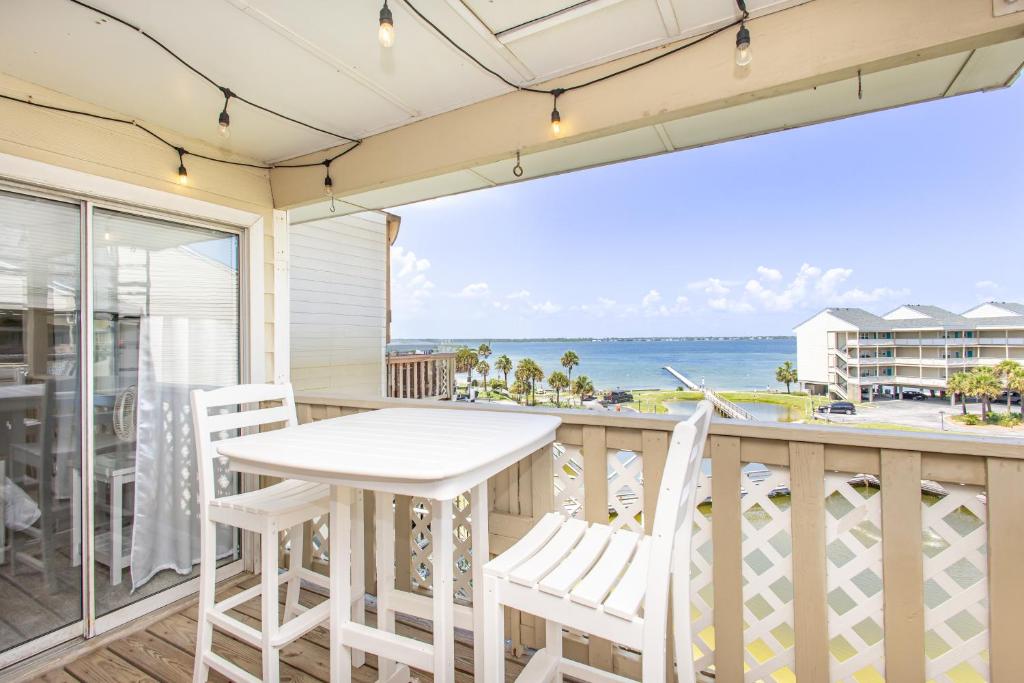 a balcony with a table and chairs and a view of the ocean at Baywatch D11 in Pensacola Beach