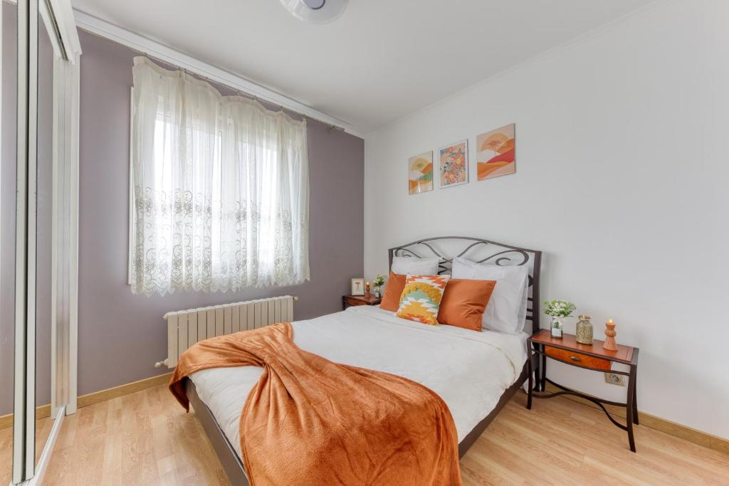- une chambre avec un lit recouvert d'une couverture orange dans l'établissement Maison Évasion Panoramique entre Paris et Disney, à Noisy-le-Sec
