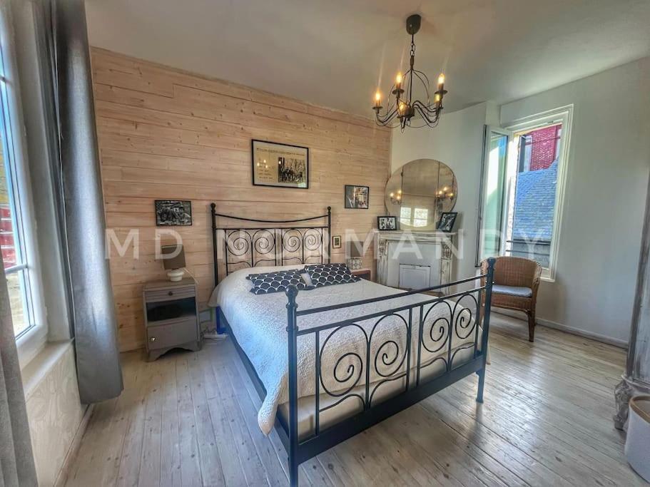 a bedroom with a bed with a wooden wall at Maison centre Villerville in Villerville