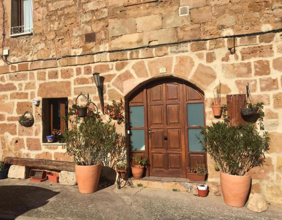 un edificio de piedra con puerta de madera y macetas en Casa Llano, en Llano de Bureba