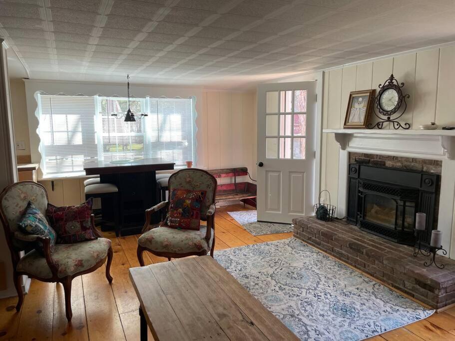 a living room with a fireplace and a table and chairs at The Hideaway in Brewster