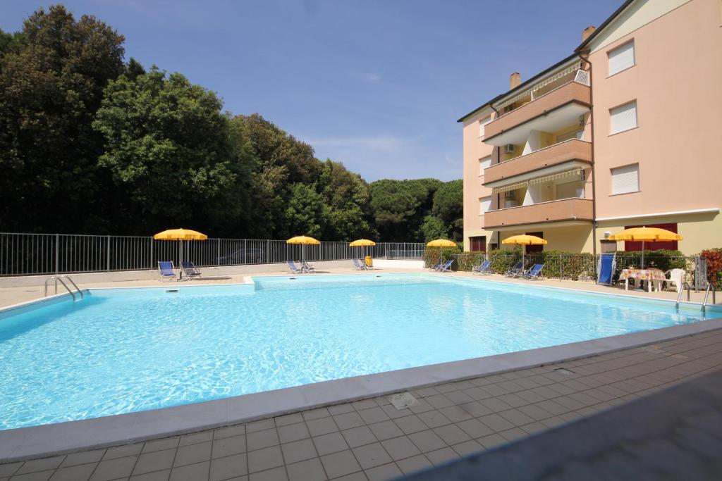 a large swimming pool in front of a building at Lovely 3 room flat in Rosolina with shared pool in Rosolina Mare