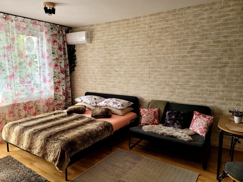 a bedroom with a bed and a couch at Apartman "CHARLIZE" with PRIVATЕ PARKING in Novi Sad