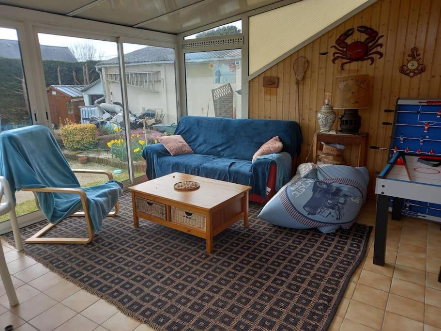 un salon avec un canapé bleu et une table dans l'établissement maison de famille bord mer doublon, à Sarzeau