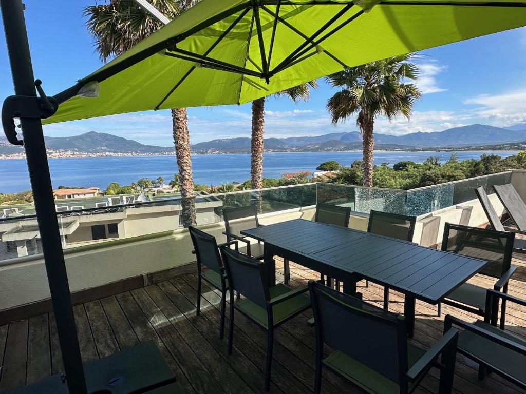 - une table et des chaises sur une terrasse avec vue sur l'océan dans l'établissement Appartement Porticcio - Vue sur le golfe - tout confort - idéalement situé, à Grosseto-Prugna