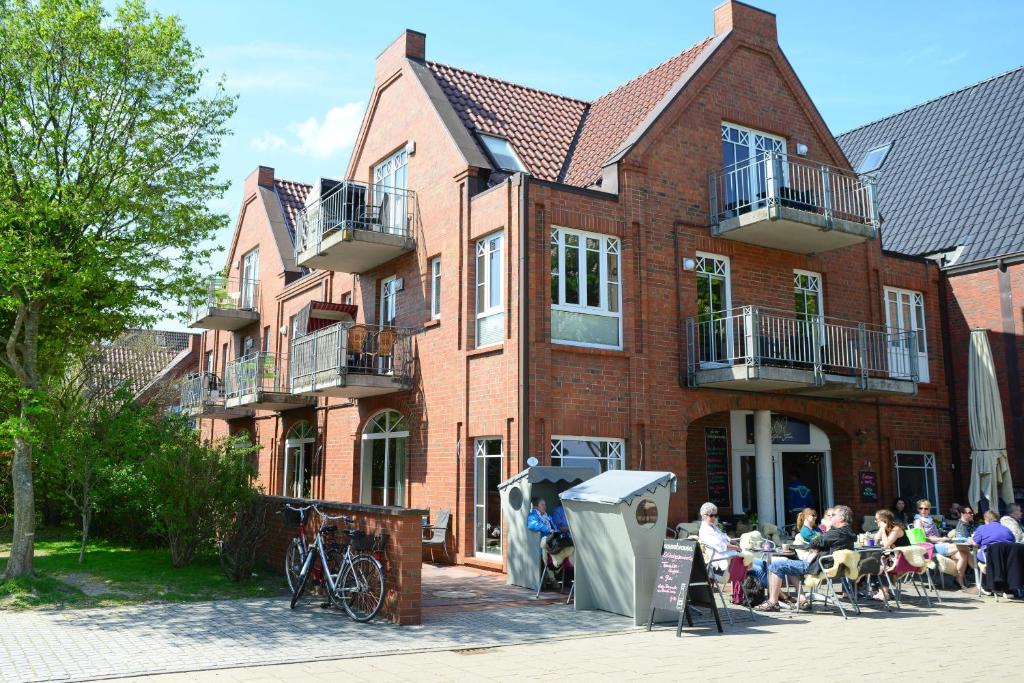 un gruppo di persone seduti fuori da un edificio di mattoni di Haus Martens Whg 02 a Wyk auf Föhr