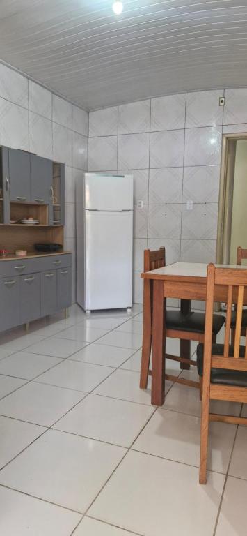una cucina con un tavolo e un frigorifero bianco di Casa Celeste a Boa Vista