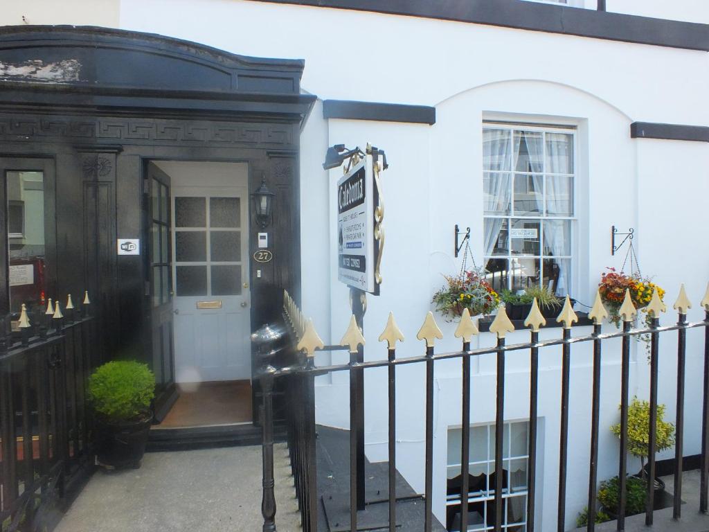 a black fence in front of a white building at Caledonia Guest House in Plymouth