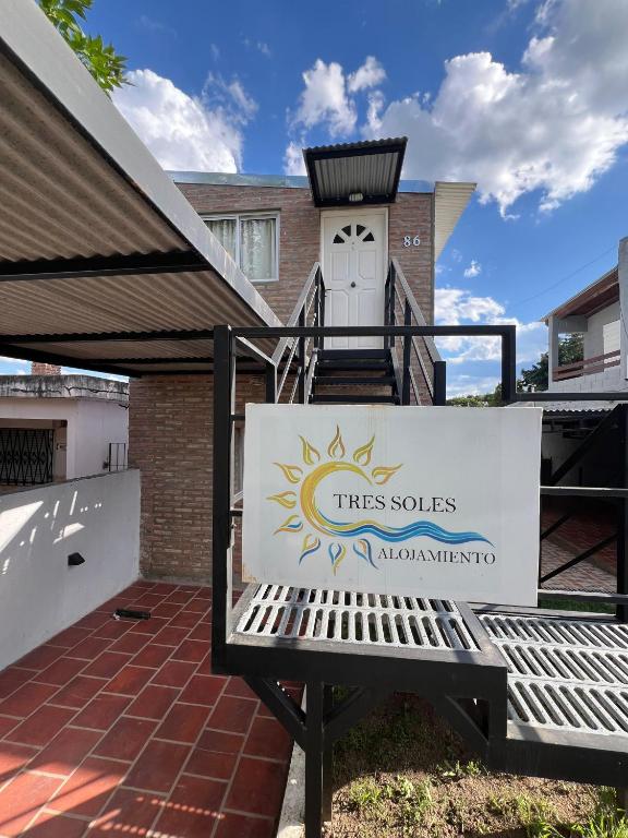 a sign sitting on a bench in front of a house at Tres Soles in Salsipuedes
