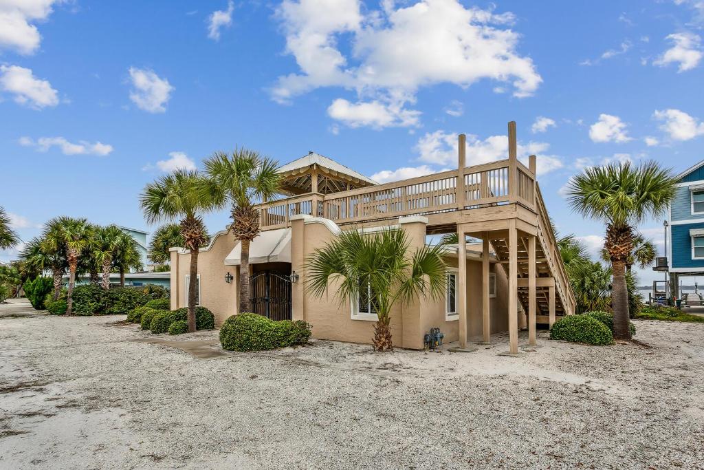 a house on the beach with palm trees at Stay Exceptional - 3B Beach Home in Pensacola Beach