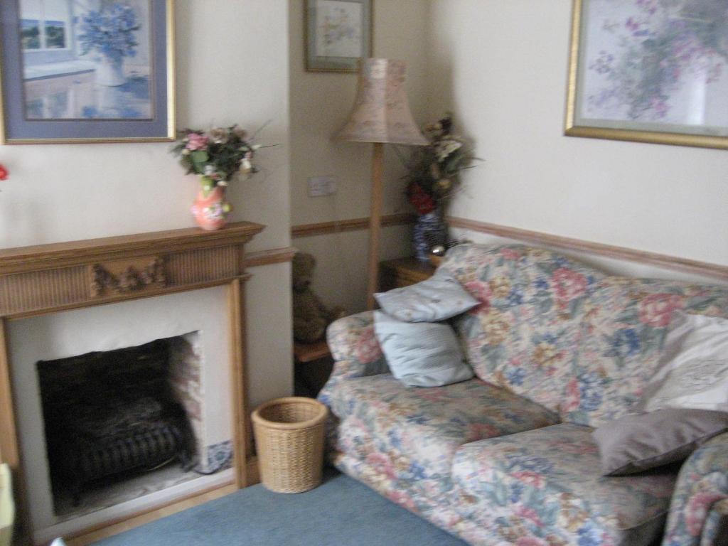 ein Wohnzimmer mit Couch und Kamin in der Unterkunft Cosy character cottage conservation area in St Albans