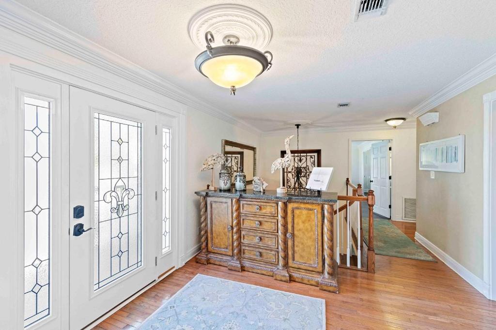 a living room with a wooden dresser and a door at Sea Breeze - 5B Beach Home in Pensacola Beach