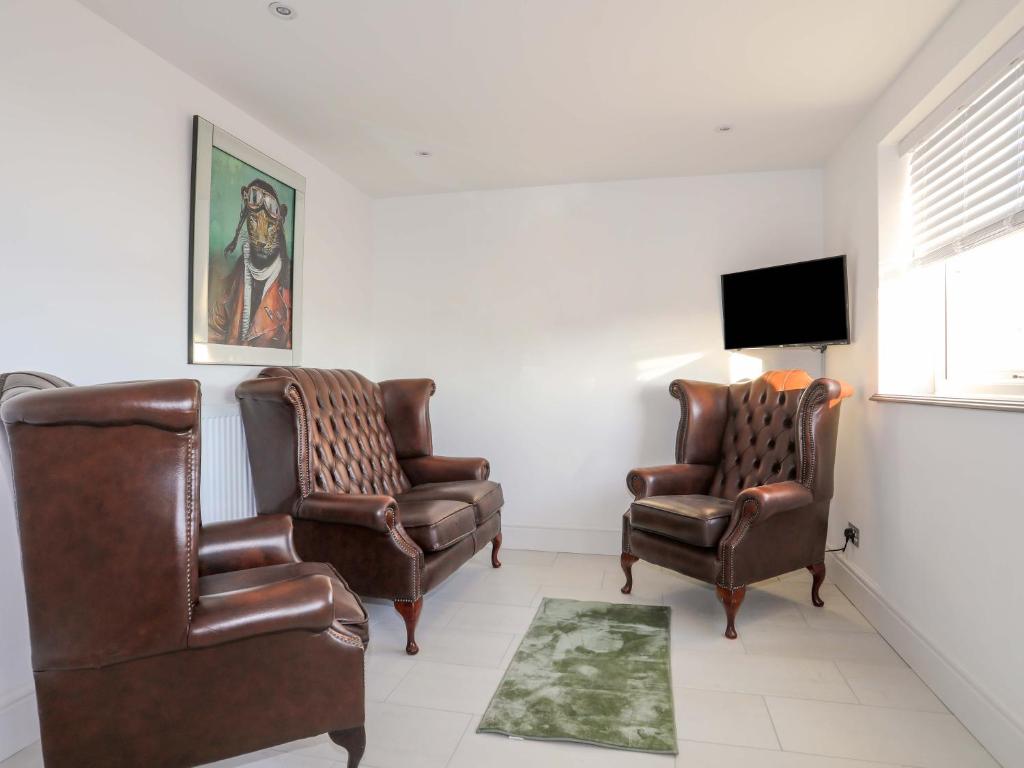 a living room with two chairs and a tv at Ty'n Ffridd Bach in Pwllheli