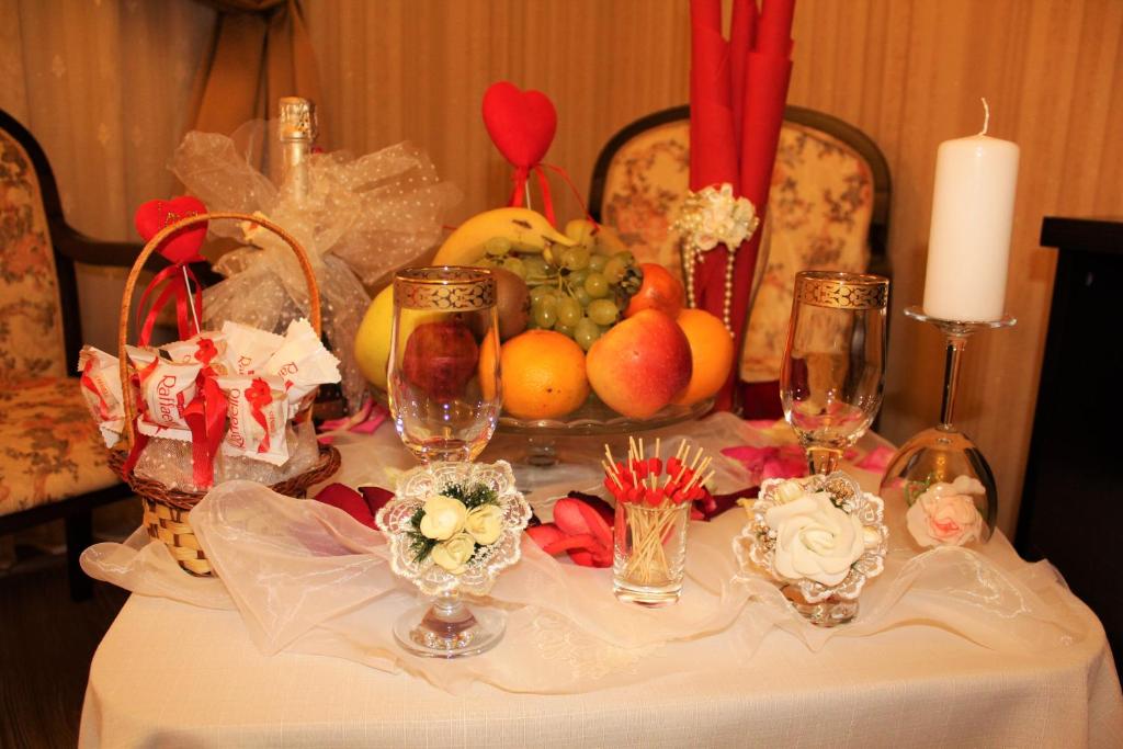 クラスノダールにあるGeorge Hotelの果物とろうそくを盛り付けたテーブル