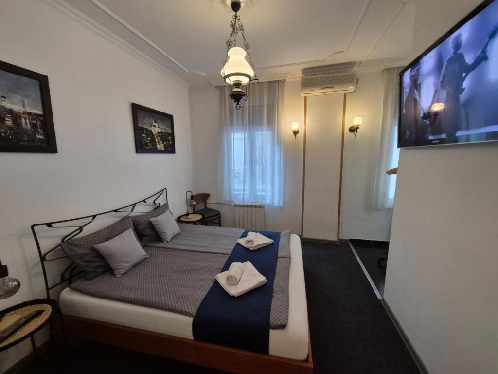 una camera da letto con un letto con due asciugamani sopra di Authentic Belgrade Centre Hostel - Only Private Rooms, Paid Parking on-site, Mandatory Reservation a Belgrado