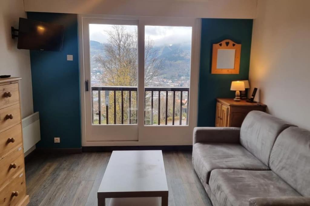 un salon avec un canapé et une grande fenêtre dans l'établissement Le petit Géromois - Free parking, à Gérardmer