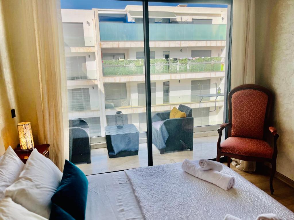 a bedroom with a bed and a large window at Appartement bord de mer Agadir in Agadir