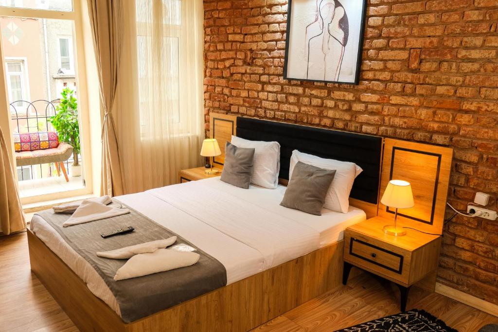 ein Schlafzimmer mit einem Bett und einer Ziegelwand in der Unterkunft Taksim Nikea Suites 80 in Istanbul