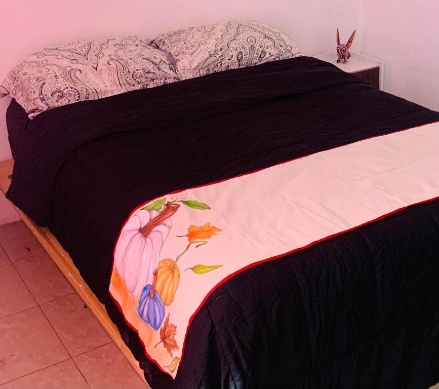 - un lit avec une couverture noire et blanche dans l'établissement Geranios, à Oaxaca
