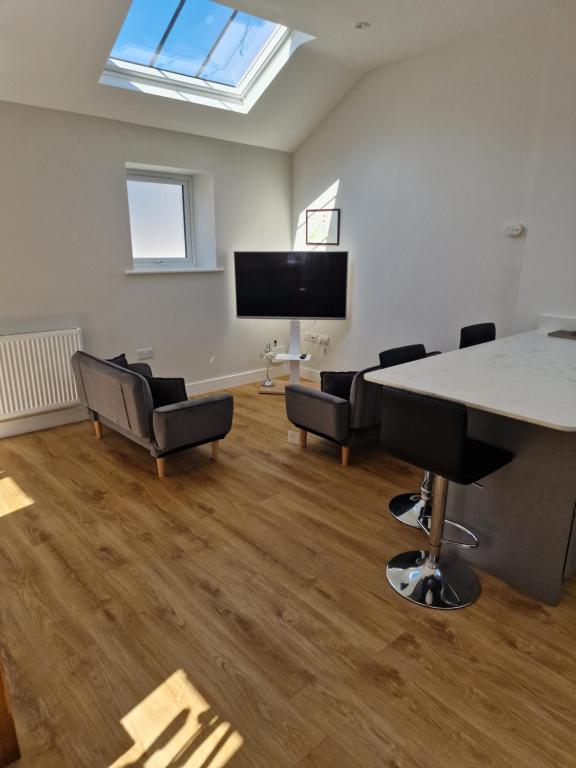Una habitación con una mesa y sillas y un televisor. en Town Centre Duplex 4, en Harrogate