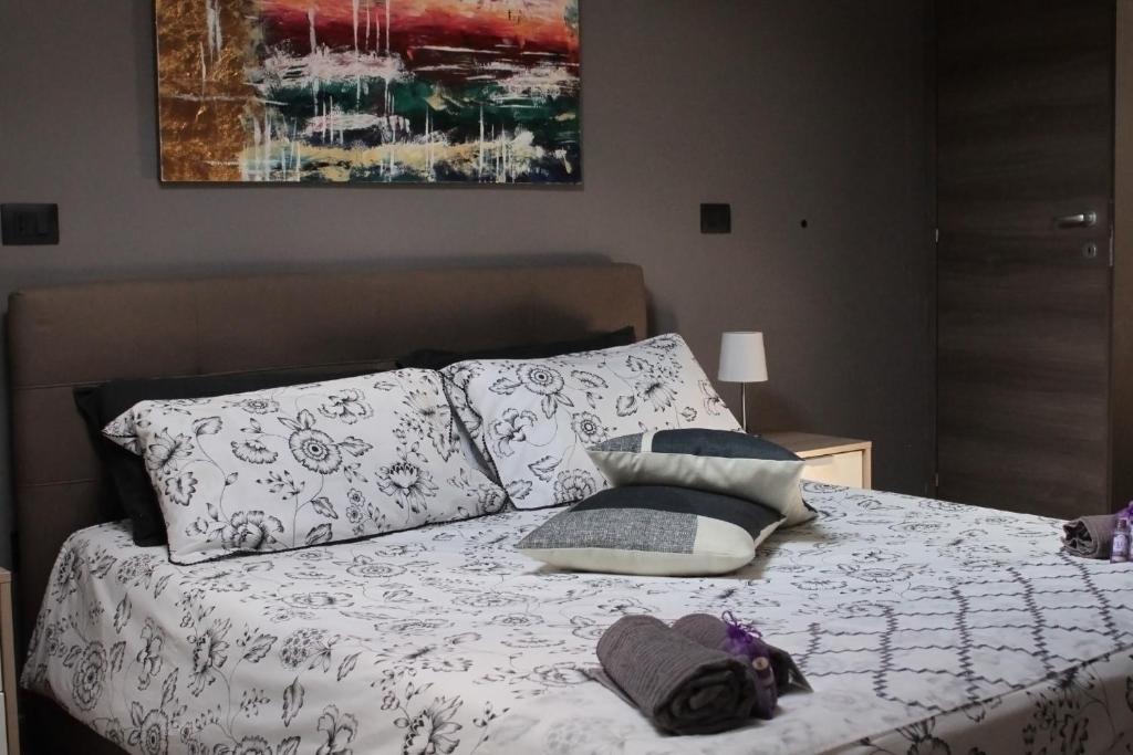 een slaapkamer met een bed met kussens en een schilderij bij Luxury Home Keops in Catania