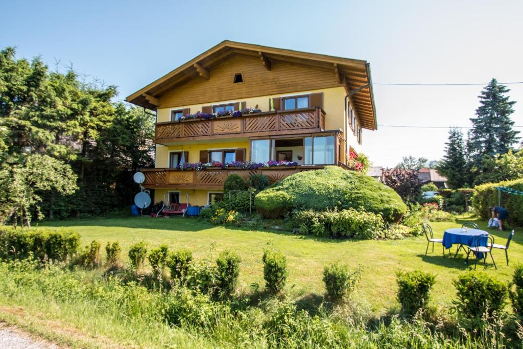 a house with a balcony on a grass field at Haus Steiner in Salzburg