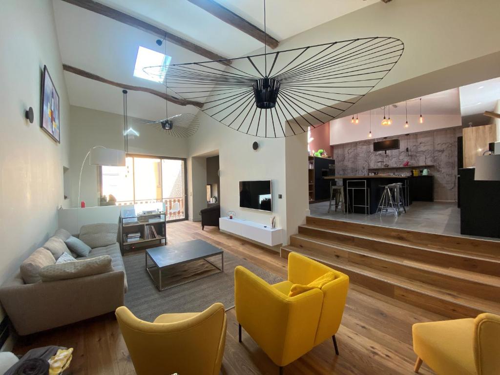 un grand salon avec un grand ventilateur suspendu au plafond dans l'établissement Maison de charme - 15 min de Lyon, à Saint-Romain-au-Mont-dʼOr