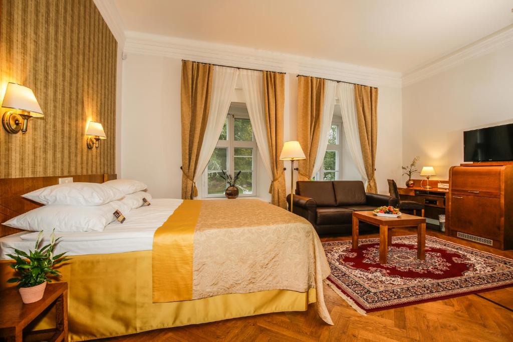 a bedroom with a bed and a chair and a couch at Vihula Manor Country Club & Spa in Vihula