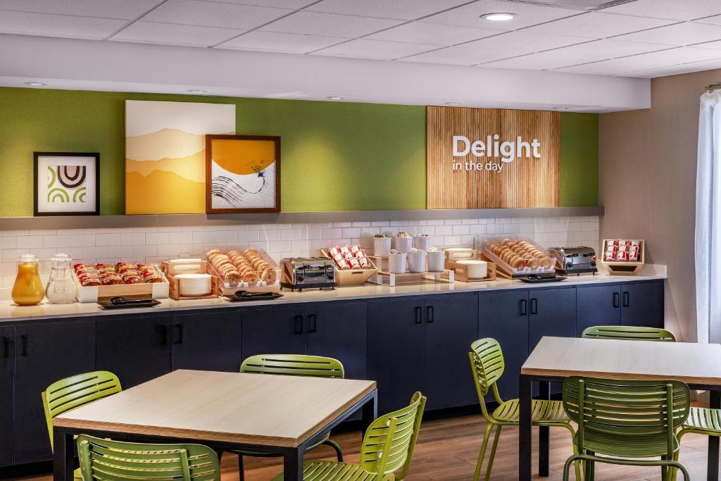 a restaurant with tables and chairs and a buffet with donuts at Spark by Hilton Denver International Airport in Denver