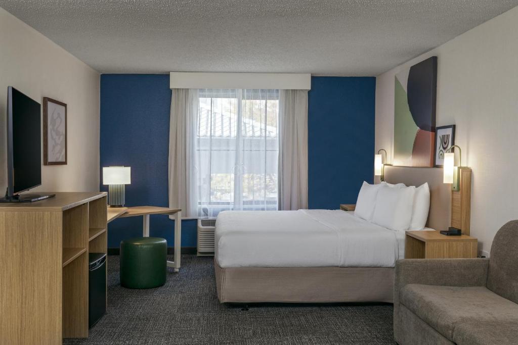 a hotel room with a bed and a couch at Spark by Hilton Denver International Airport in Denver