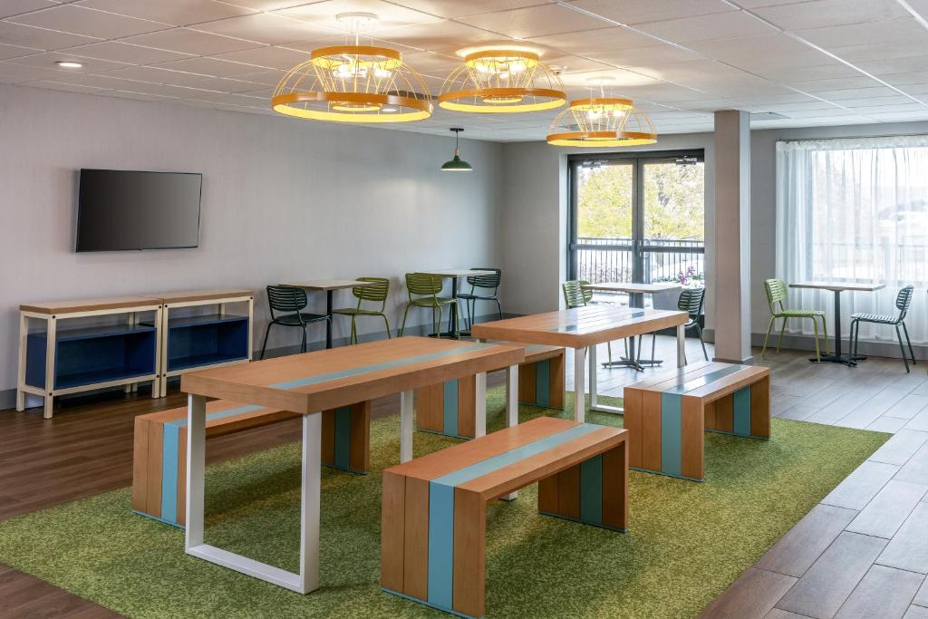 a conference room with tables and chairs and a tv at Spark by Hilton Denver International Airport in Denver