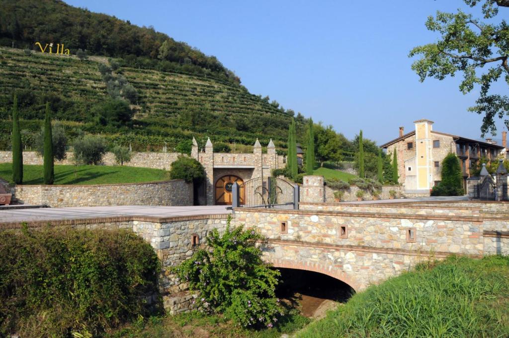 a stone bridge with a building and a mountain at Villa Gradoni in Monticelli Brusati
