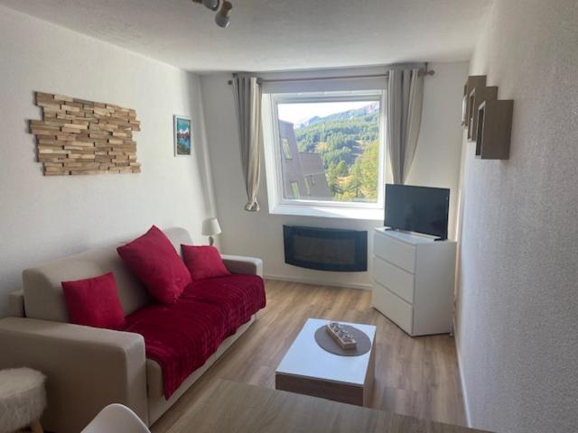 - un salon avec un canapé rouge et une fenêtre dans l'établissement Studio La Foux d'Allos les Etoiles, à Allos