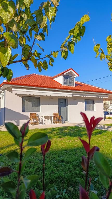 a white house with a red roof at Cozy Bungalow in Tríkala
