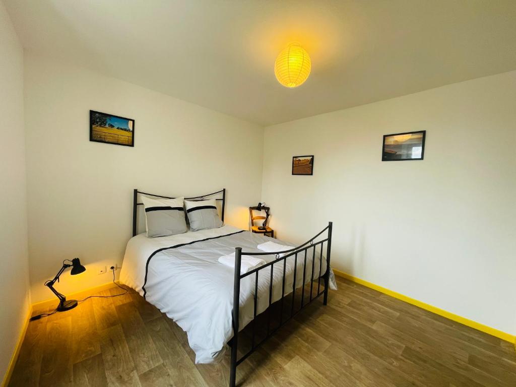 une chambre avec un lit et une lumière au plafond dans l'établissement Le Faubourg, à Saint-Jean-dʼAngély