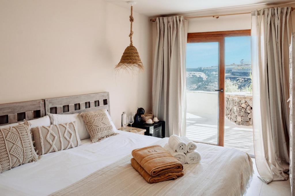 een slaapkamer met een wit bed en een groot raam bij Boutique Eco Hotel Costa Mágica in La Laguna