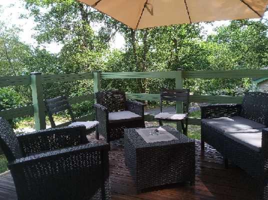 une terrasse avec des chaises, des tables et un parasol dans l'établissement Chalet 31, à Le Mas