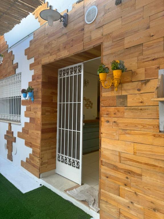 een houten muur met een poort in een huis bij Les portes délavées in Sfax