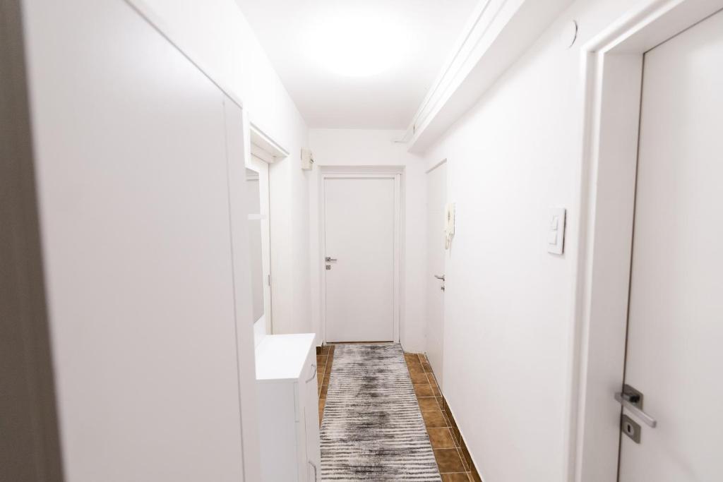 een gang met witte muren en een witte wastafel en spiegel bij Tanja in Banja Luka