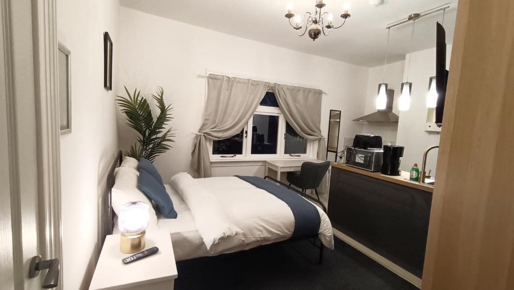 a bedroom with a bed and a desk and a window at Fulforth St Studio Apartments in Nottingham