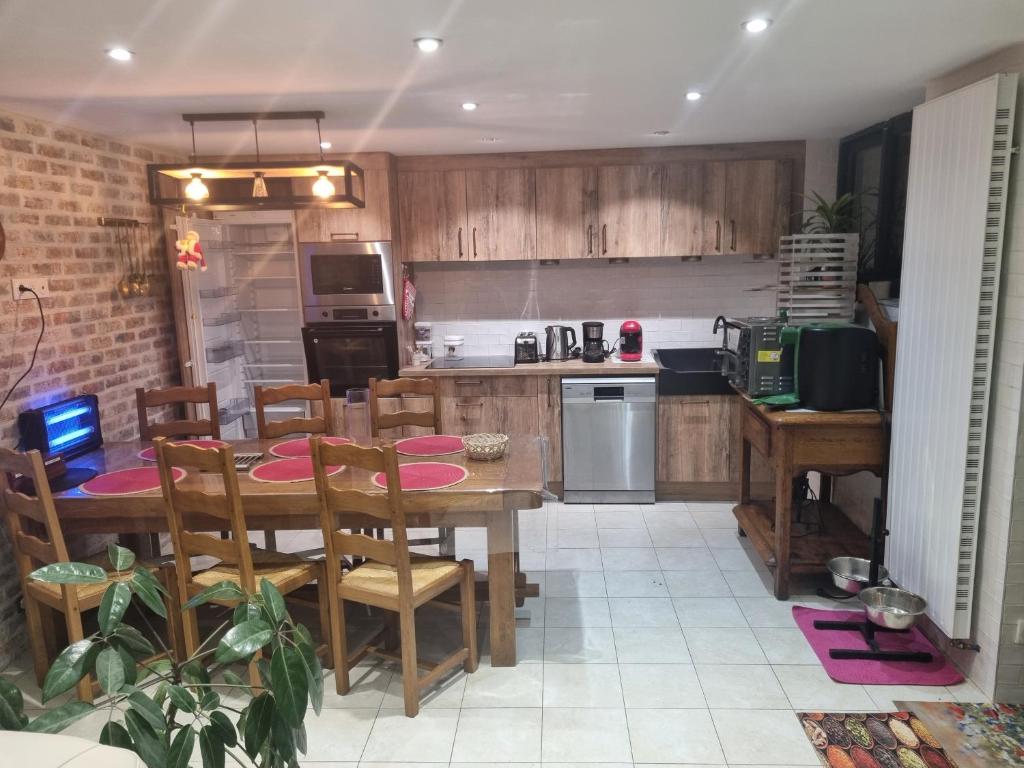 a kitchen with a table and chairs in a kitchen at La Villa Marcelle in Bucquoy