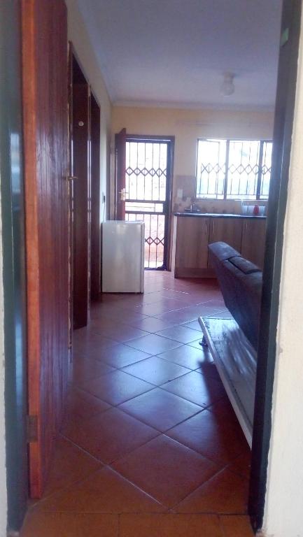 a room with a kitchen with a tiled floor at 33 On Swallows Guest House in Soshanguve