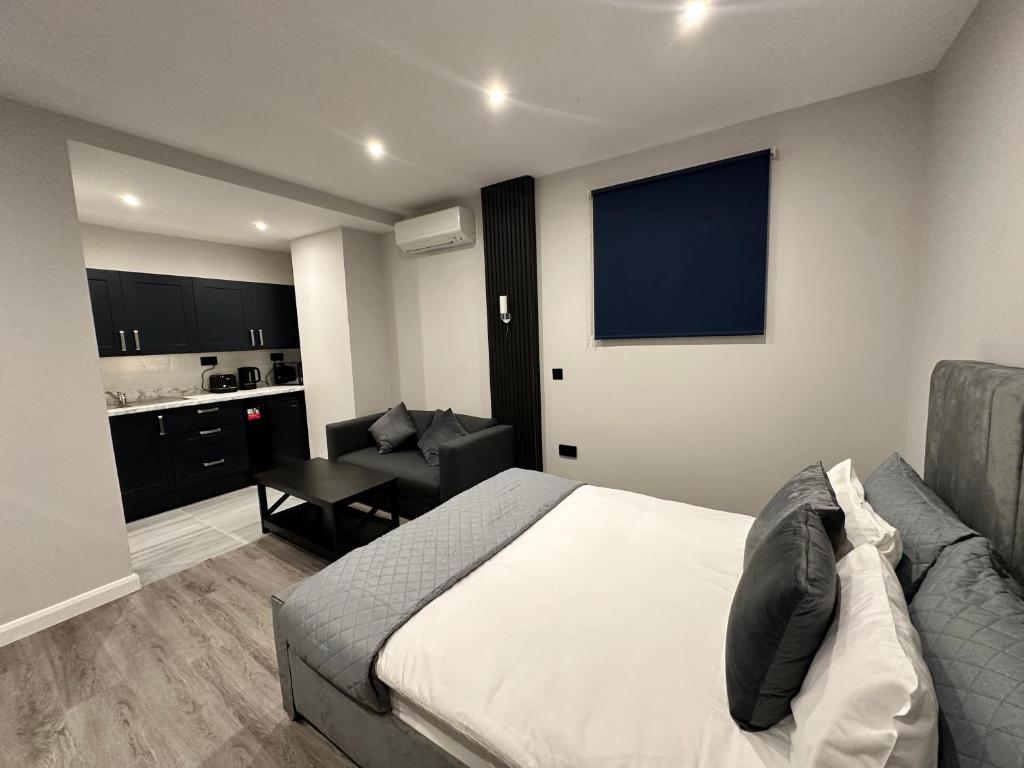 Un dormitorio con una cama y un sofá y una cocina. en Pasha Hotel - 3* Boutique Hotel, en Londres